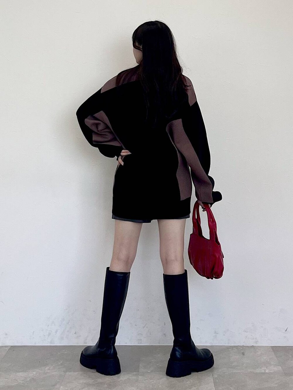 グレー系のその他パンツ、レッド系のハンドバッグ、ブラック系のブーツを着用したレディースの冬コーディネートの6枚目の写真