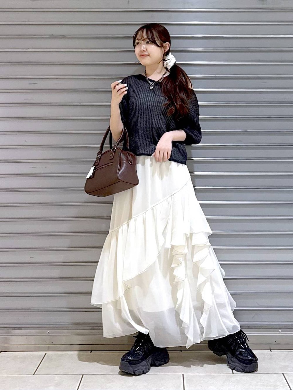 ブラック系のスニーカー、ホワイト系のスカート、ホワイト系のキャミソールを着用したレディースの夏コーディネートの2枚目の写真