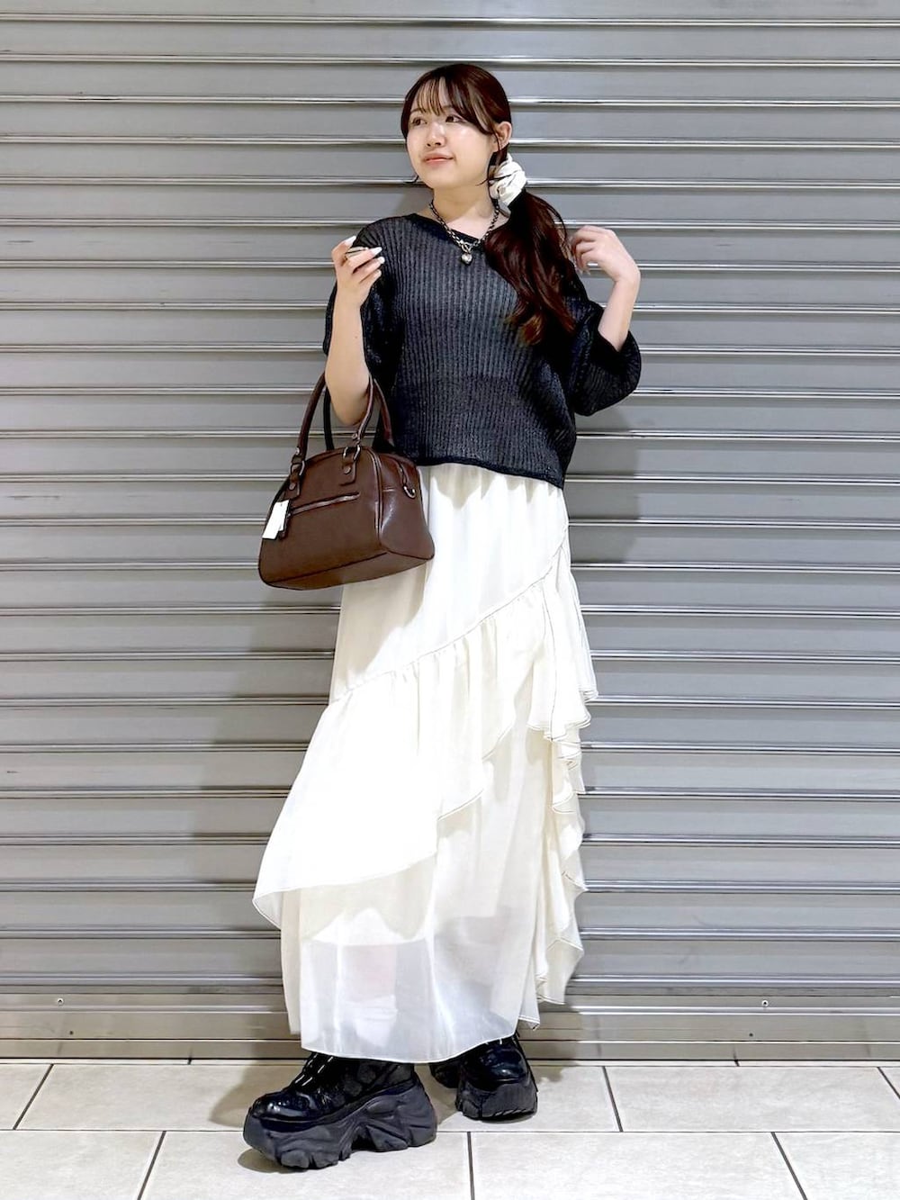 ブラック系のスニーカー、ホワイト系のスカート、ホワイト系のキャミソールを着用したレディースの夏コーディネートの3枚目の写真