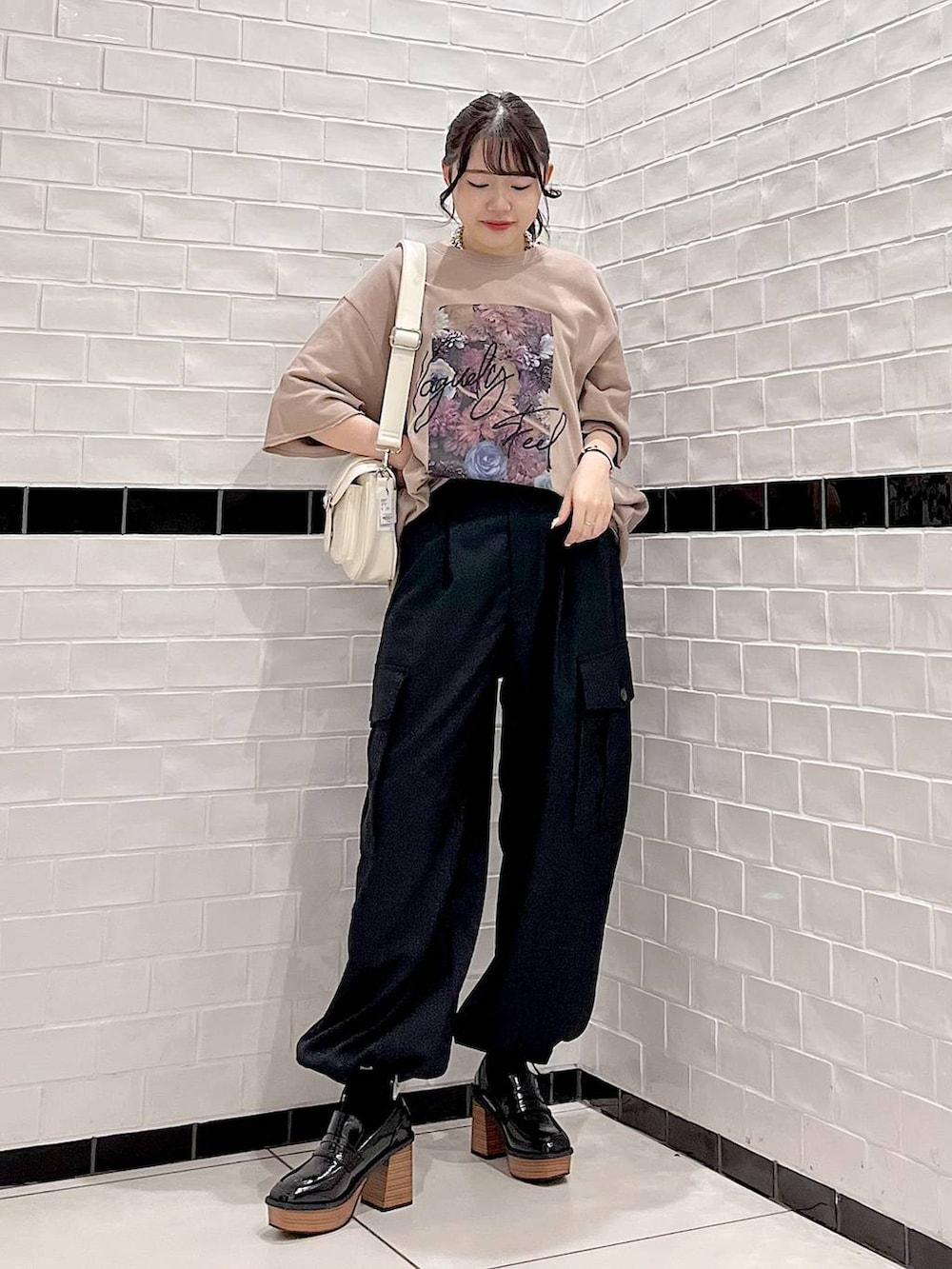 ブラウン系のTシャツ/カットソー、ブラック系のカーゴパンツ、ブラック系のローファーを着用したレディースの秋コーディネートの3枚目の写真