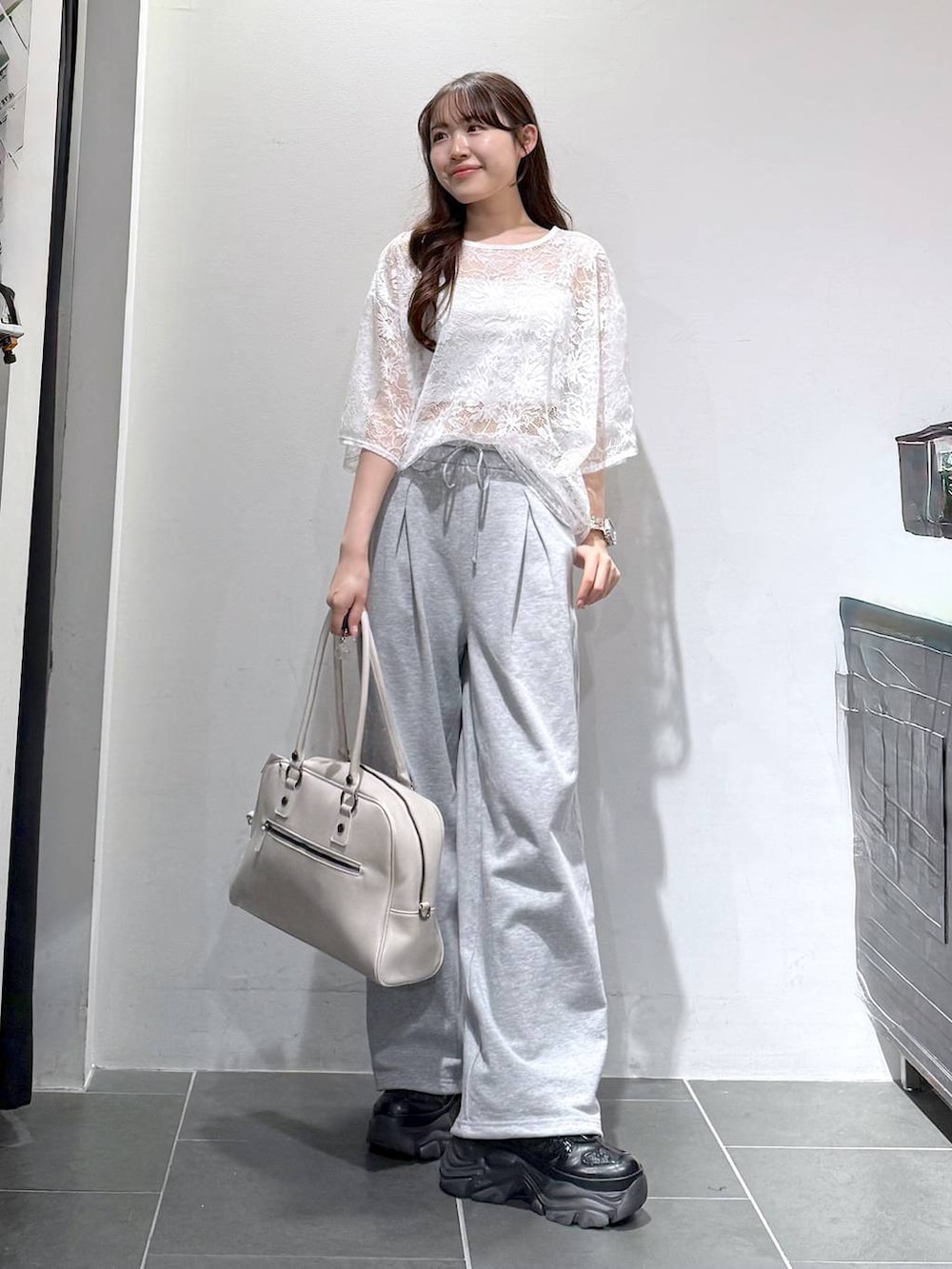 ブラック系のスニーカー、ホワイト系のボストンバッグ、ホワイト系のキャミソールを着用したレディースの春コーディネートの2枚目の写真