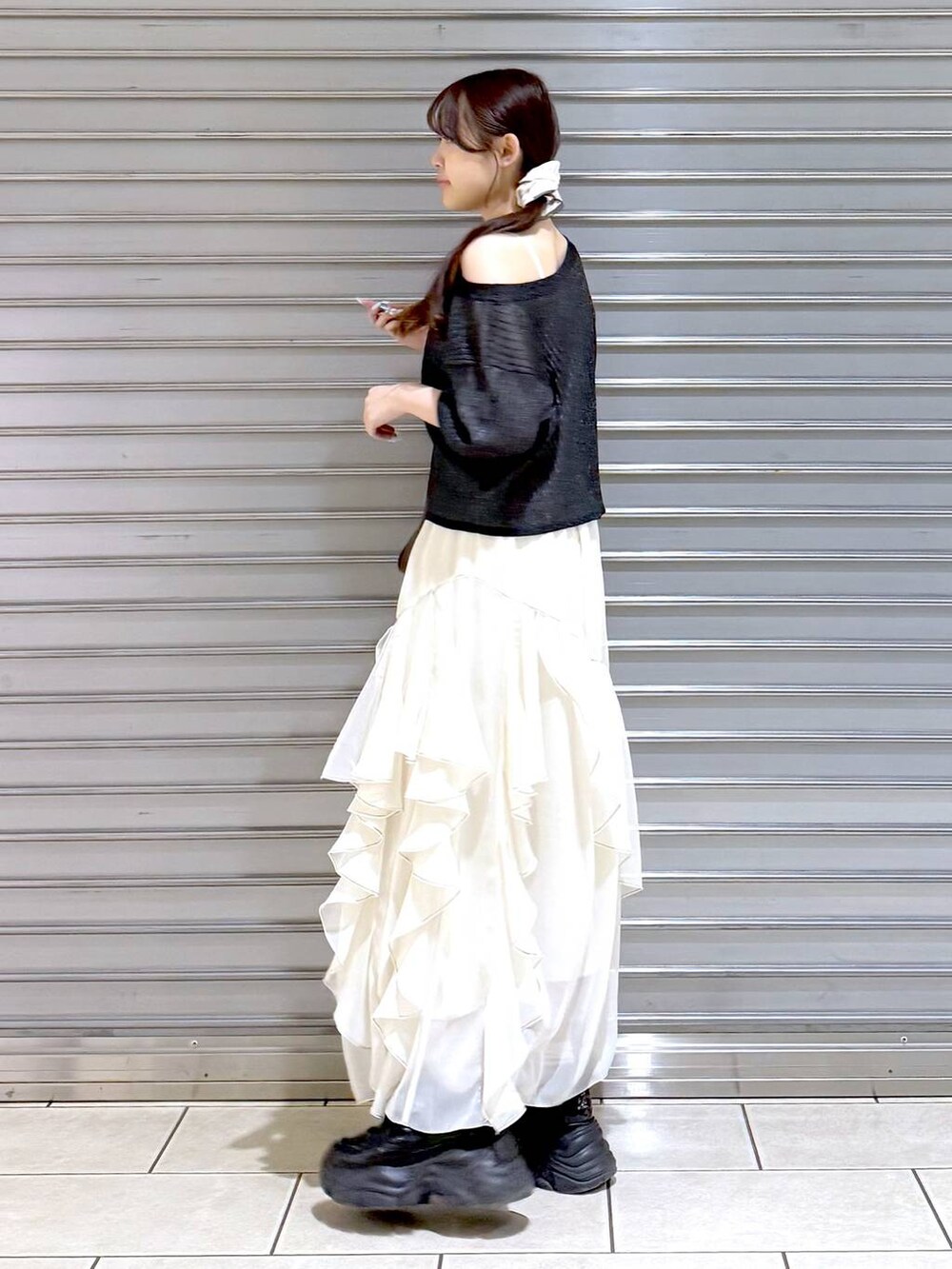 ブラック系のスニーカー、ホワイト系のスカート、ホワイト系のキャミソールを着用したレディースの夏コーディネートの4枚目の写真