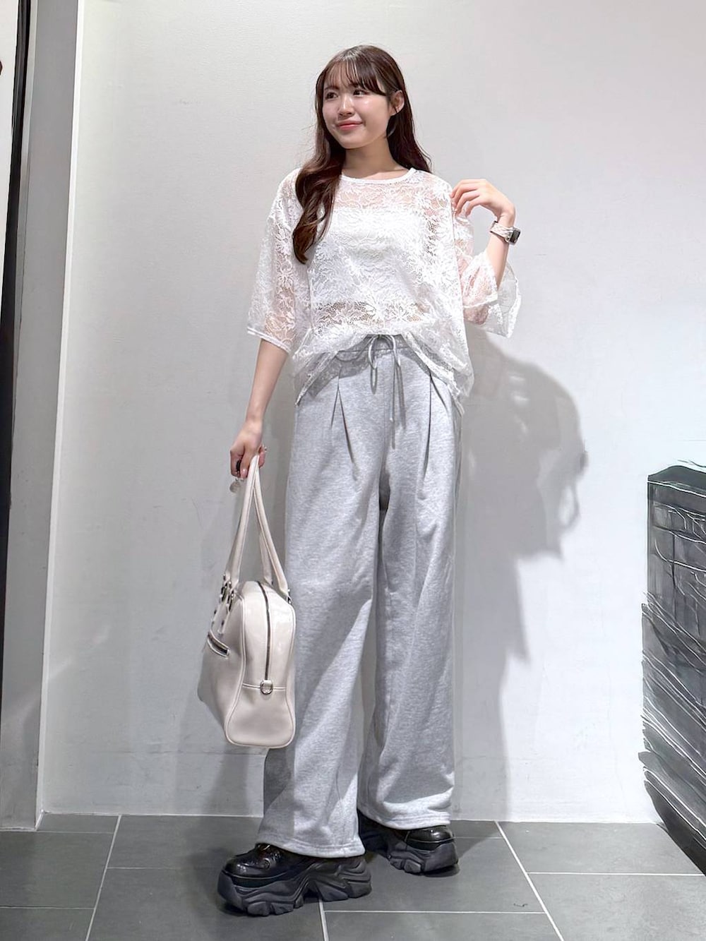 ブラック系のスニーカー、ホワイト系のボストンバッグ、ホワイト系のキャミソールを着用したレディースの春コーディネートの3枚目の写真