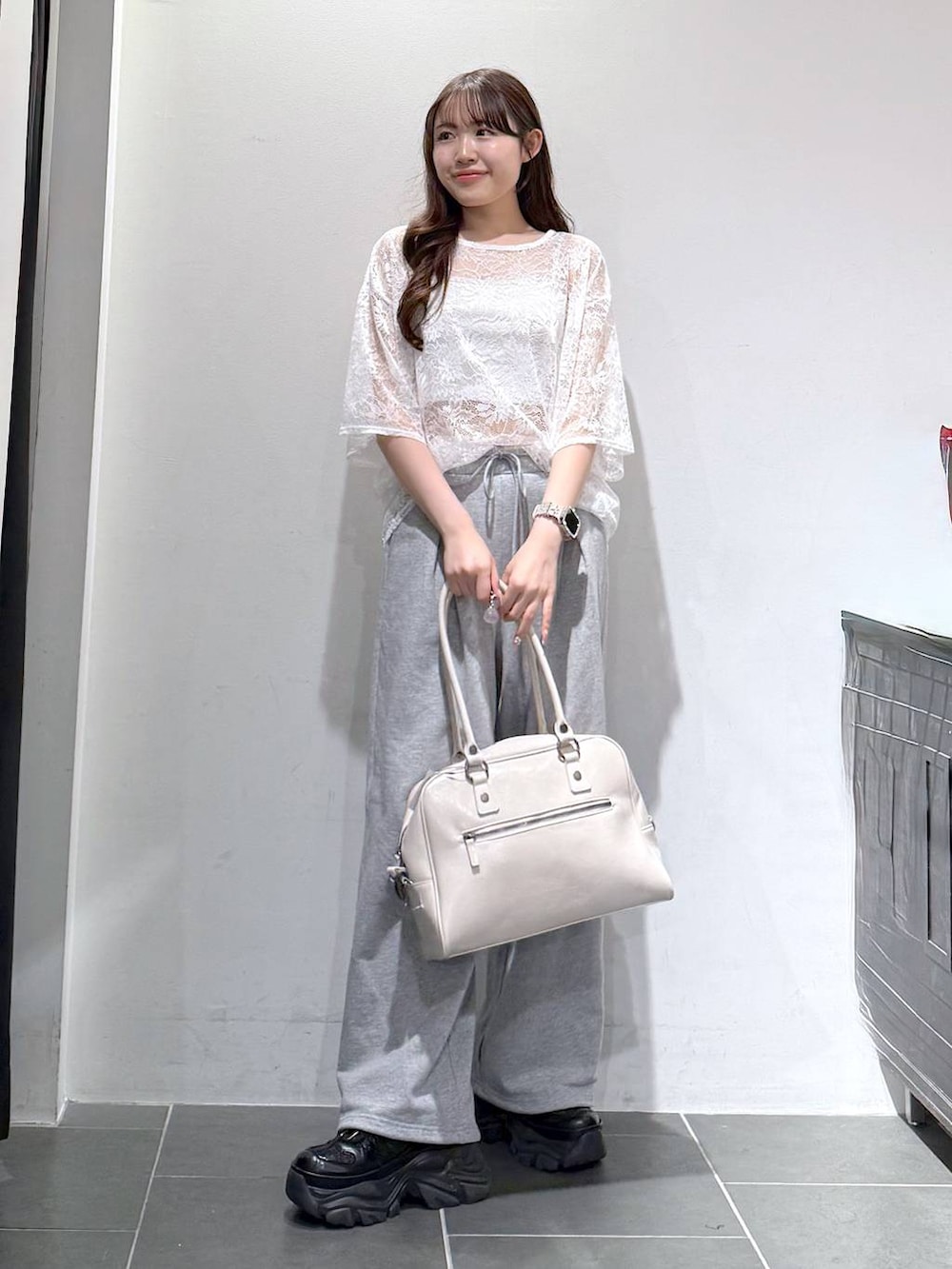 ブラック系のスニーカー、ホワイト系のボストンバッグ、ホワイト系のキャミソールを着用したレディースの春コーディネートの4枚目の写真