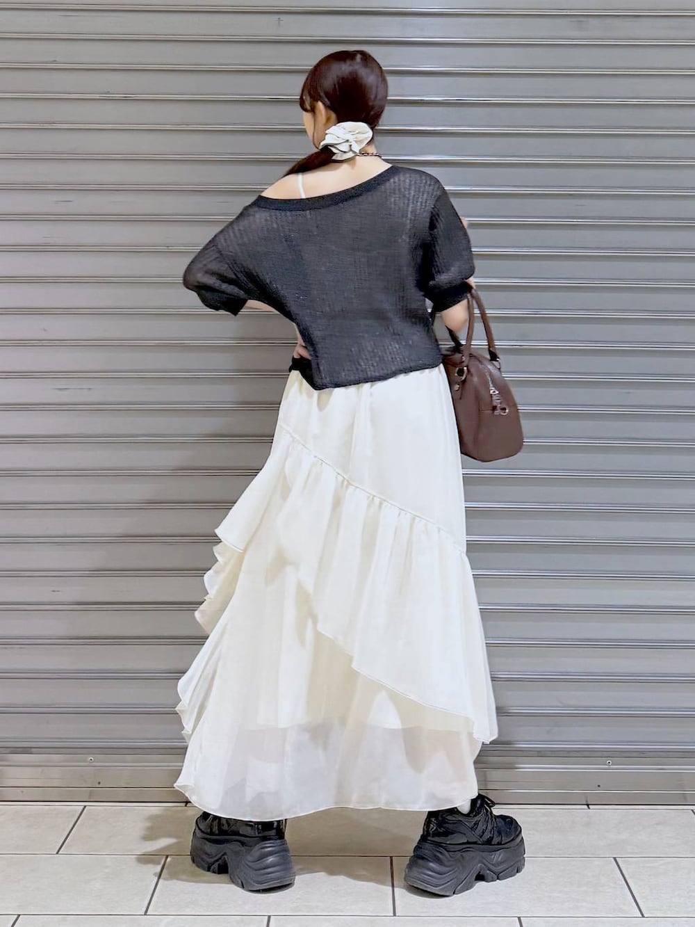 ブラック系のスニーカー、ホワイト系のスカート、ホワイト系のキャミソールを着用したレディースの夏コーディネートの5枚目の写真