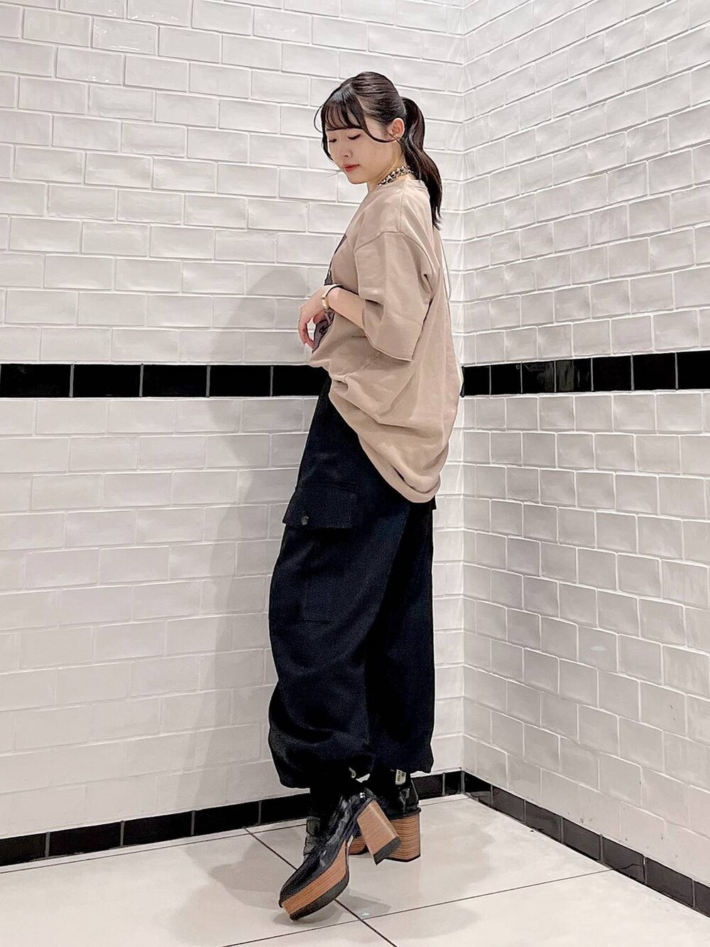 ブラウン系のTシャツ/カットソー、ブラック系のカーゴパンツ、ブラック系のローファーを着用したレディースの秋コーディネートの4枚目の写真