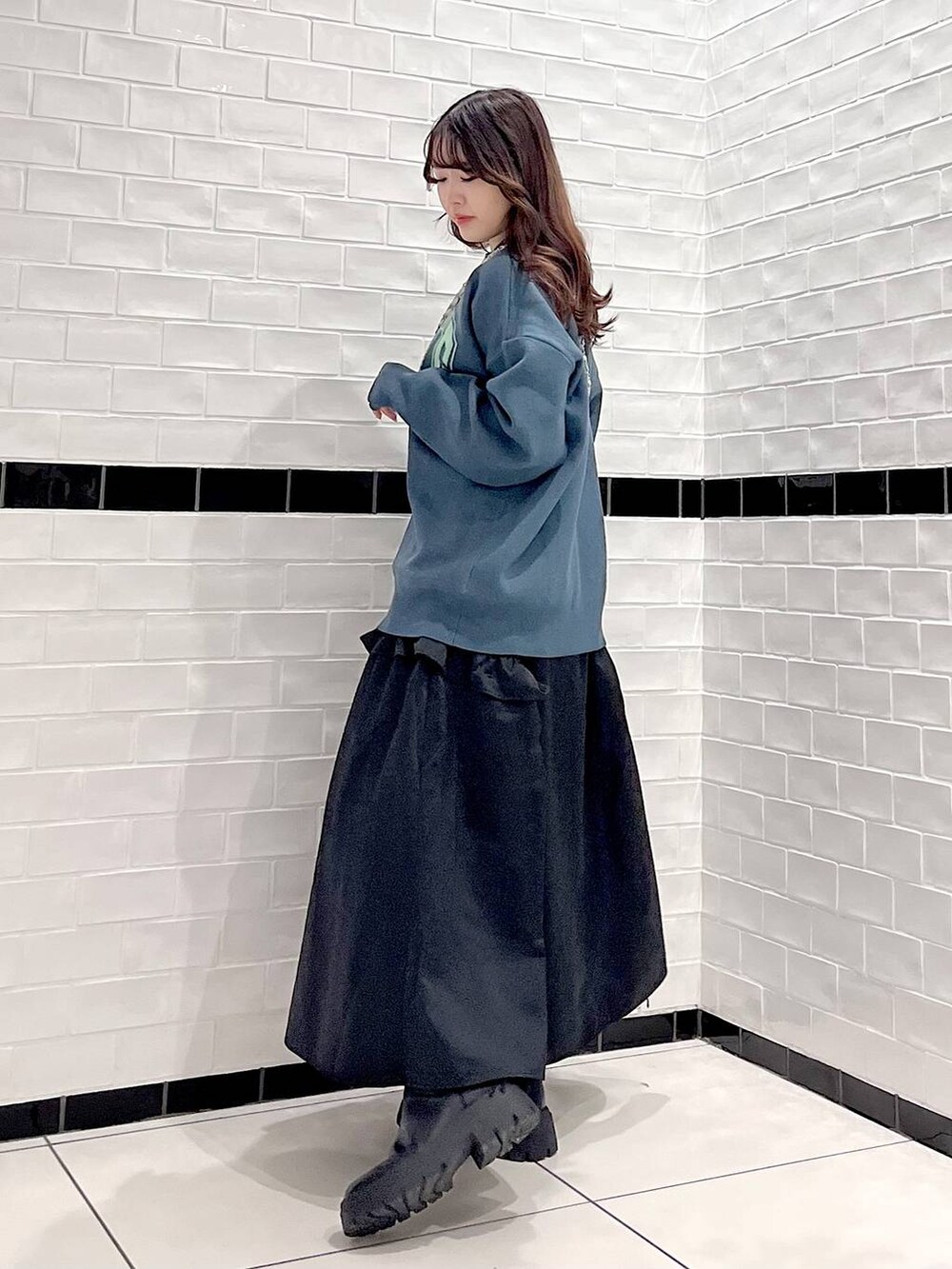 ブラック系のブーツ、シルバー系のショルダーバッグ、グリーン系のニット/セーターを着用したレディースの冬コーディネートの4枚目の写真