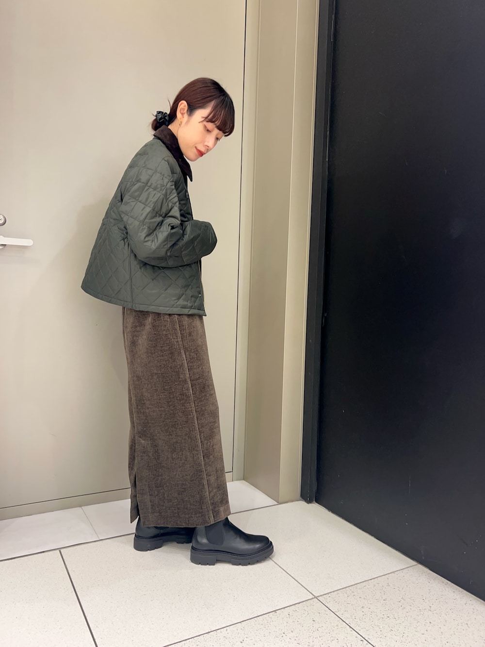 グリーン系のその他アウター、ブラウン系のスカートを着用したレディースの秋コーディネートの2枚目の写真