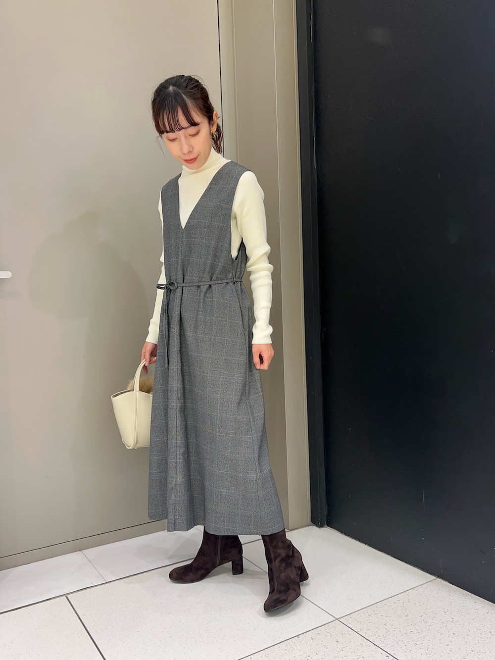 ホワイト系のニット/セーター、その他のワンピース、ブラウン系のブーツを着用したレディースの秋コーディネートの2枚目の写真