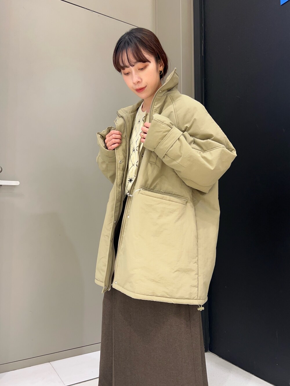 ベージュ系のニット/セーター、ブルー系のダウンジャケット/コート、ブラウン系のスカートを着用したレディースの秋コーディネートの5枚目の写真