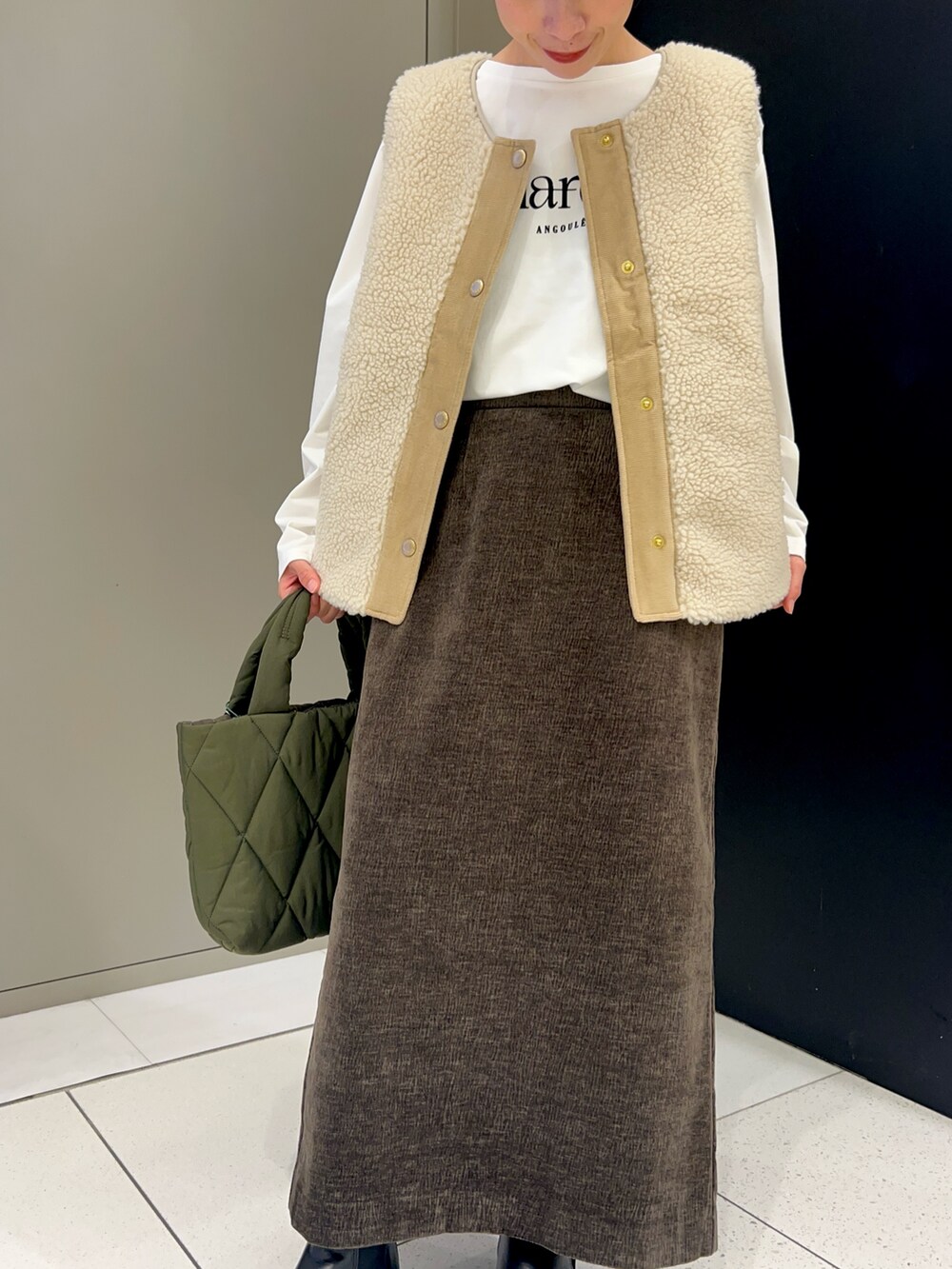 ホワイト系のベスト、ホワイト系のTシャツ/カットソー、ブラウン系のスカートを着用したレディースの秋コーディネートの4枚目の写真