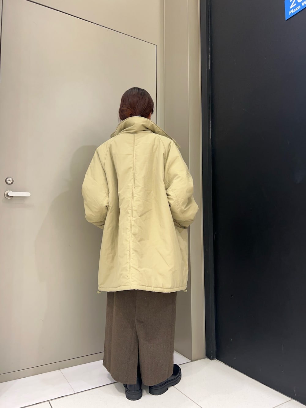 ベージュ系のニット/セーター、ブルー系のダウンジャケット/コート、ブラウン系のスカートを着用したレディースの秋コーディネートの4枚目の写真