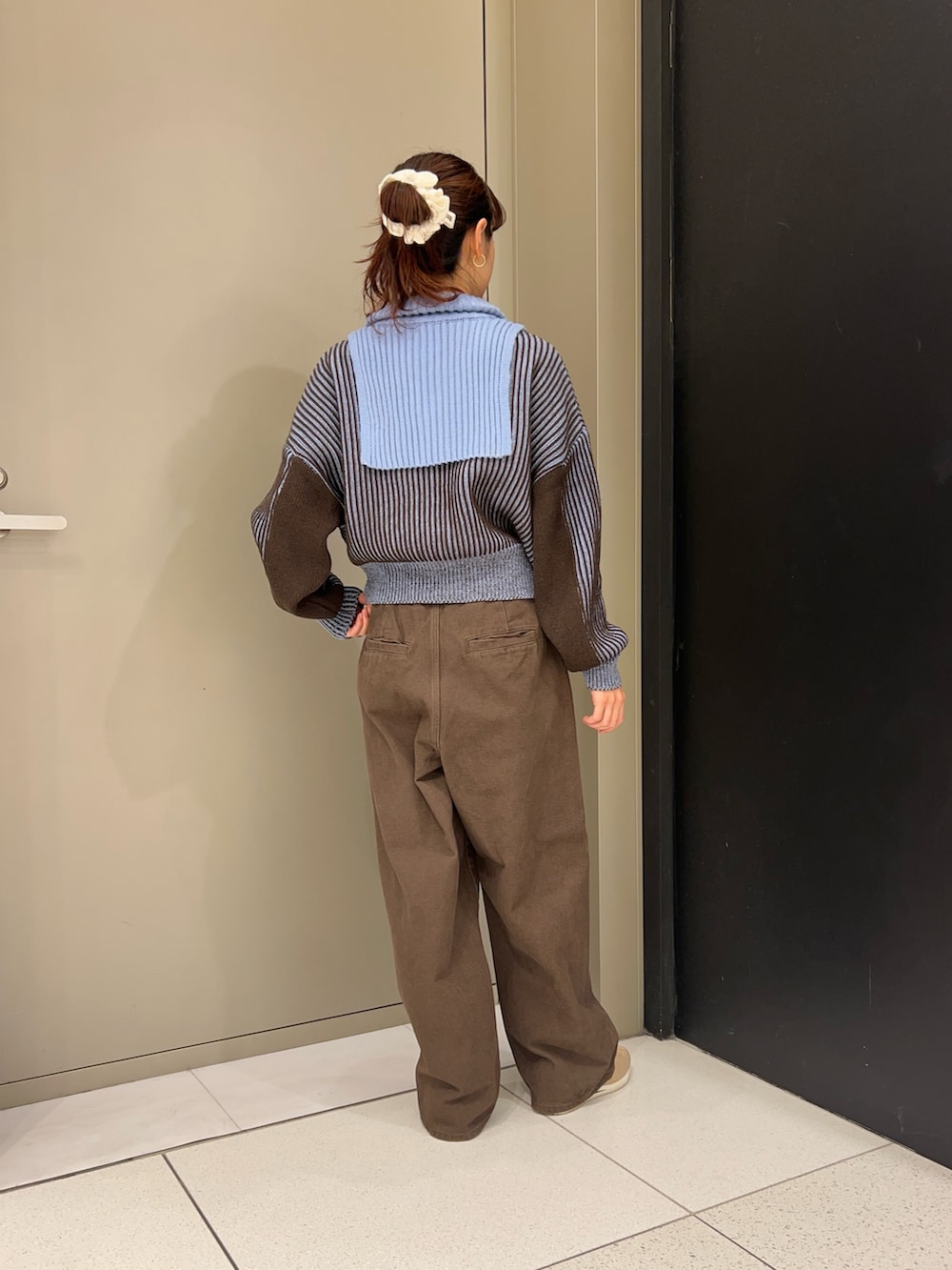 ブルー系のニット/セーター、ブラウン系のその他パンツを着用したレディースの秋コーディネートの3枚目の写真