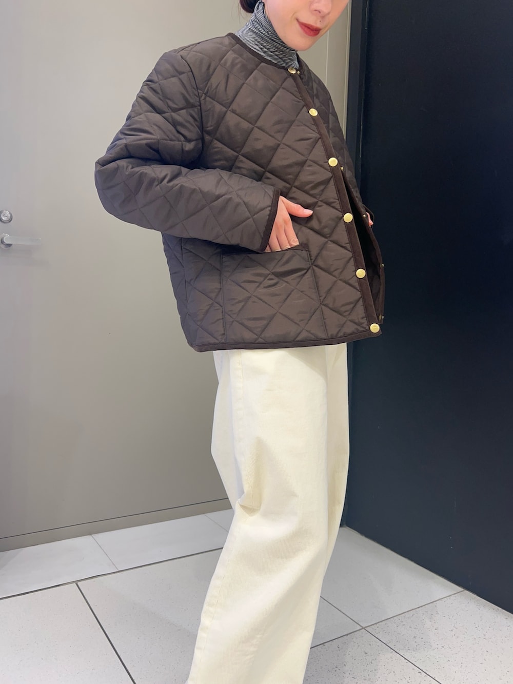 ブラウン系のノーカラーコート、ブラック系のTシャツ/カットソー、ホワイト系のその他パンツを着用したレディースの秋コーディネートの4枚目の写真