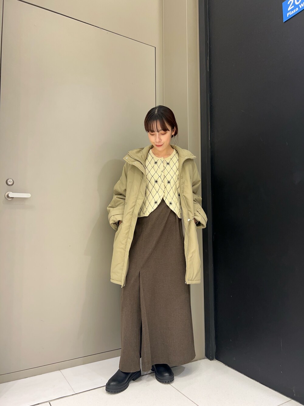 ベージュ系のニット/セーター、ブルー系のダウンジャケット/コート、ブラウン系のスカートを着用したレディースの秋コーディネートの2枚目の写真