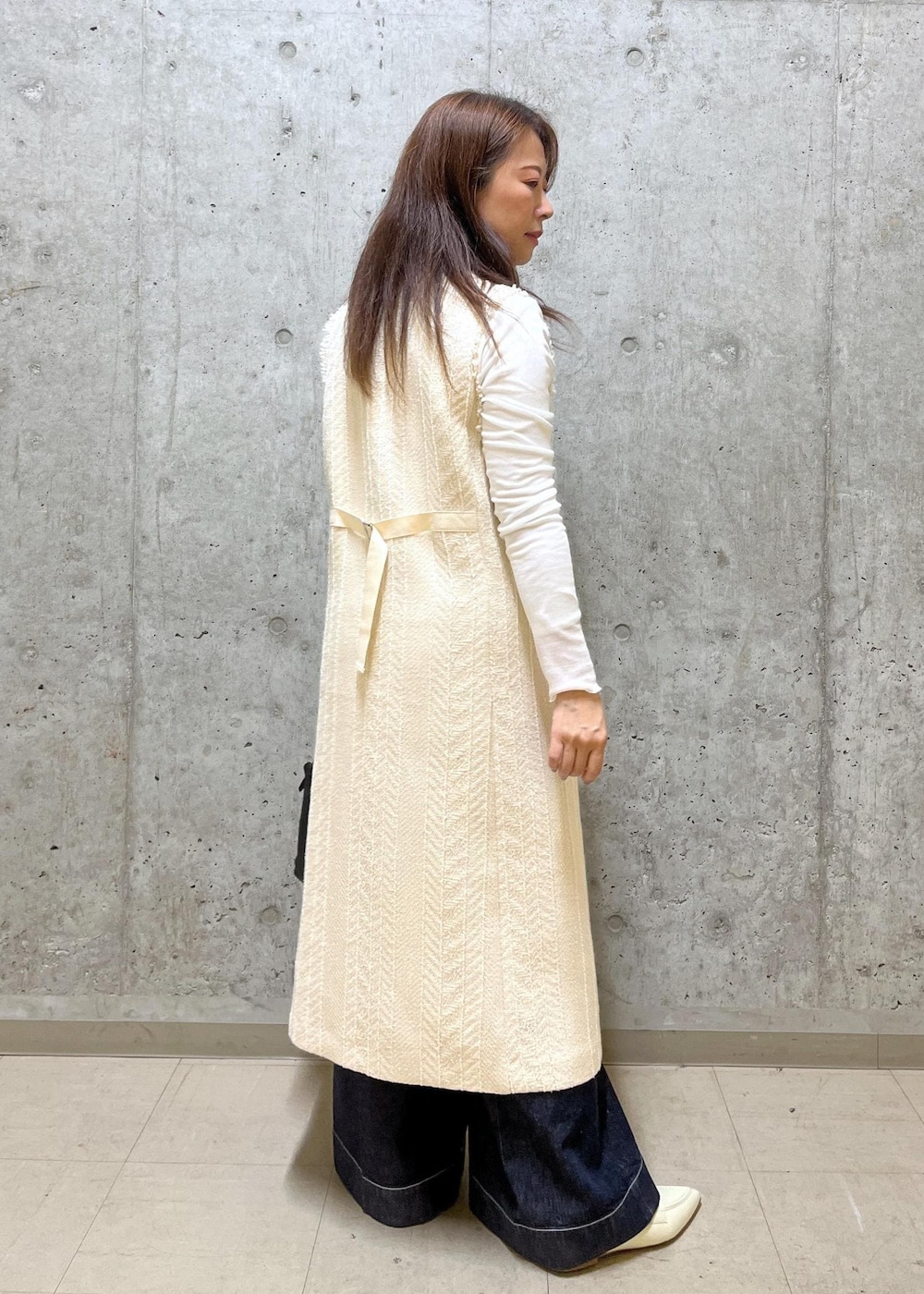 ブラック系のハンドバッグ、ホワイト系のパンプス、ホワイト系のTシャツ/カットソーを着用したレディースの春コーディネートの3枚目の写真