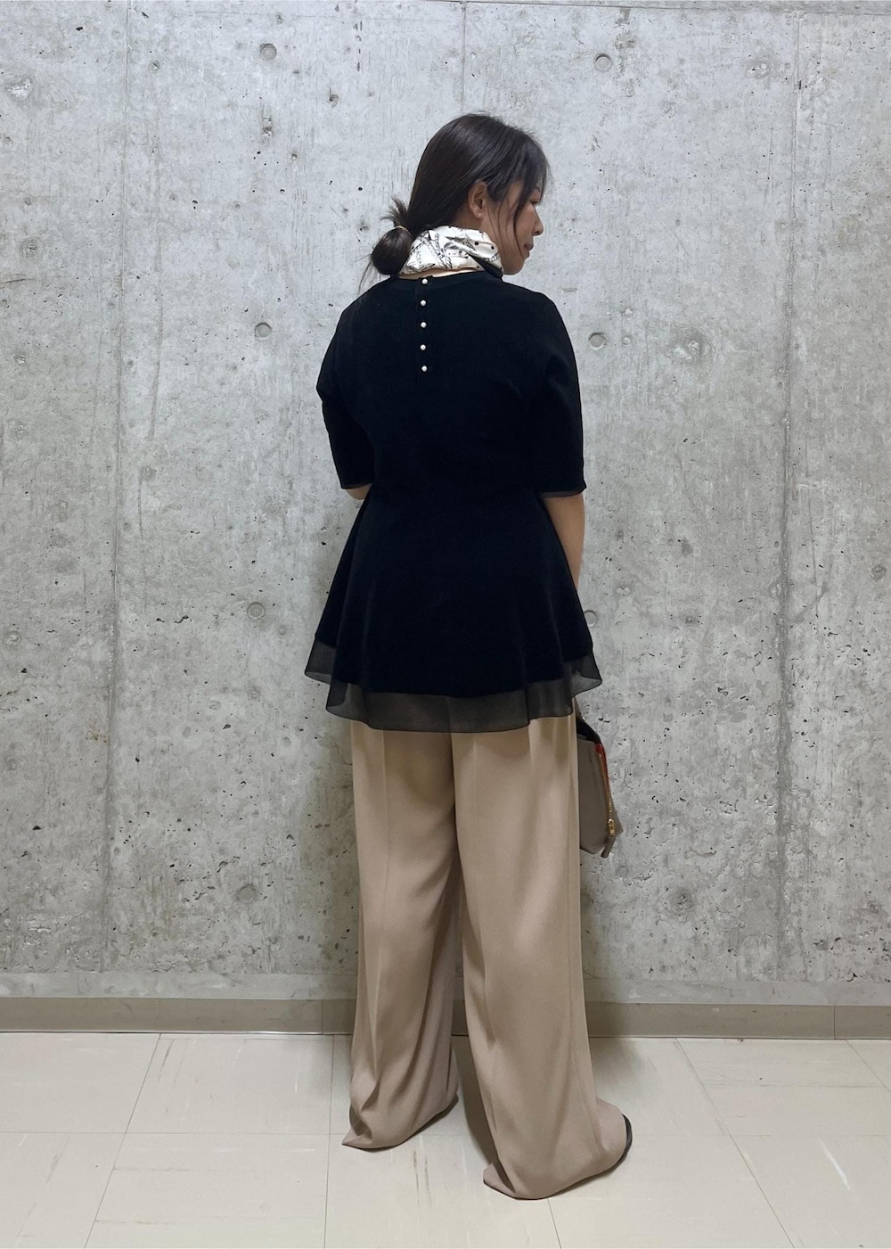 ブラウン系のハンドバッグ、ベージュ系のその他パンツ、ブラック系のローファーを着用したレディースの秋コーディネートの3枚目の写真