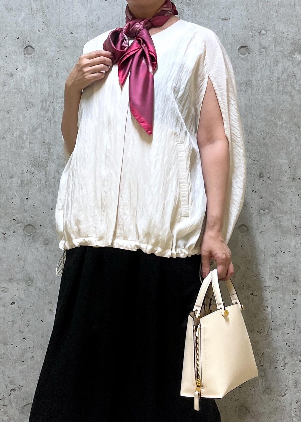 ホワイト系のキャミソール、ベージュ系のハンドバッグ、レッド系のパンプスを着用したレディースの夏コーディネートの5枚目の写真