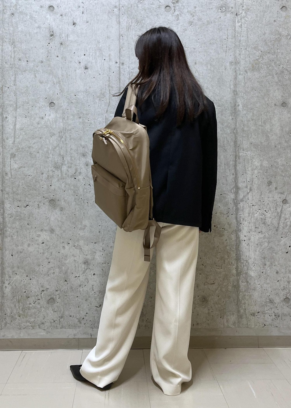 ブラック系のパンプス、ベージュ系のバックパック/リュック、ベージュ系のその他パンツを着用したレディースの冬コーディネートの3枚目の写真