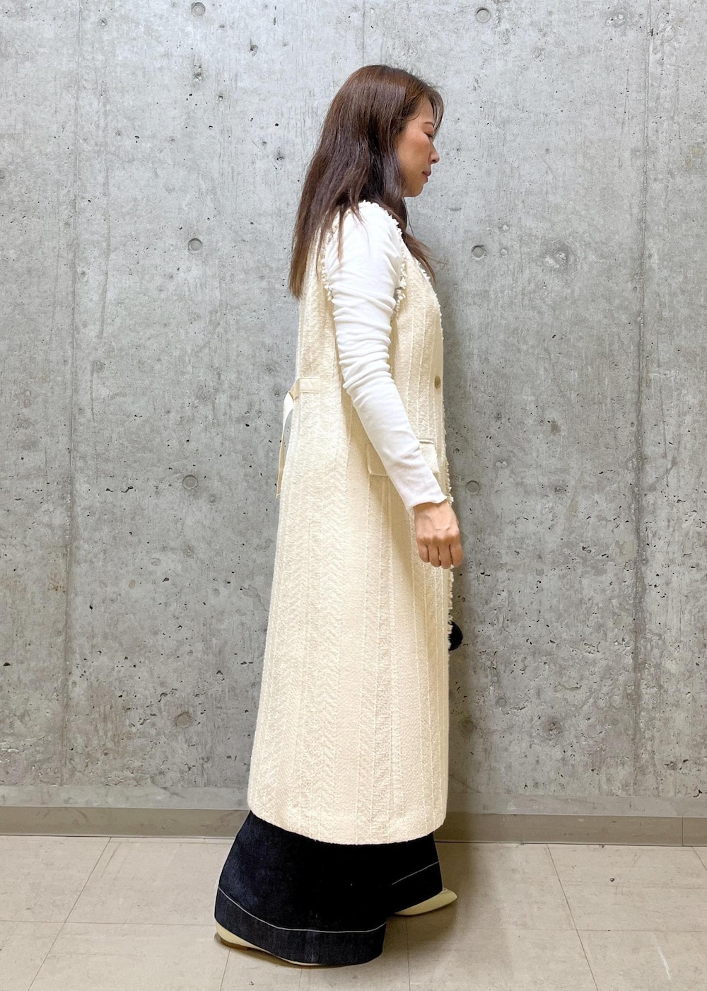 ブラック系のハンドバッグ、ホワイト系のパンプス、ホワイト系のTシャツ/カットソーを着用したレディースの春コーディネートの2枚目の写真