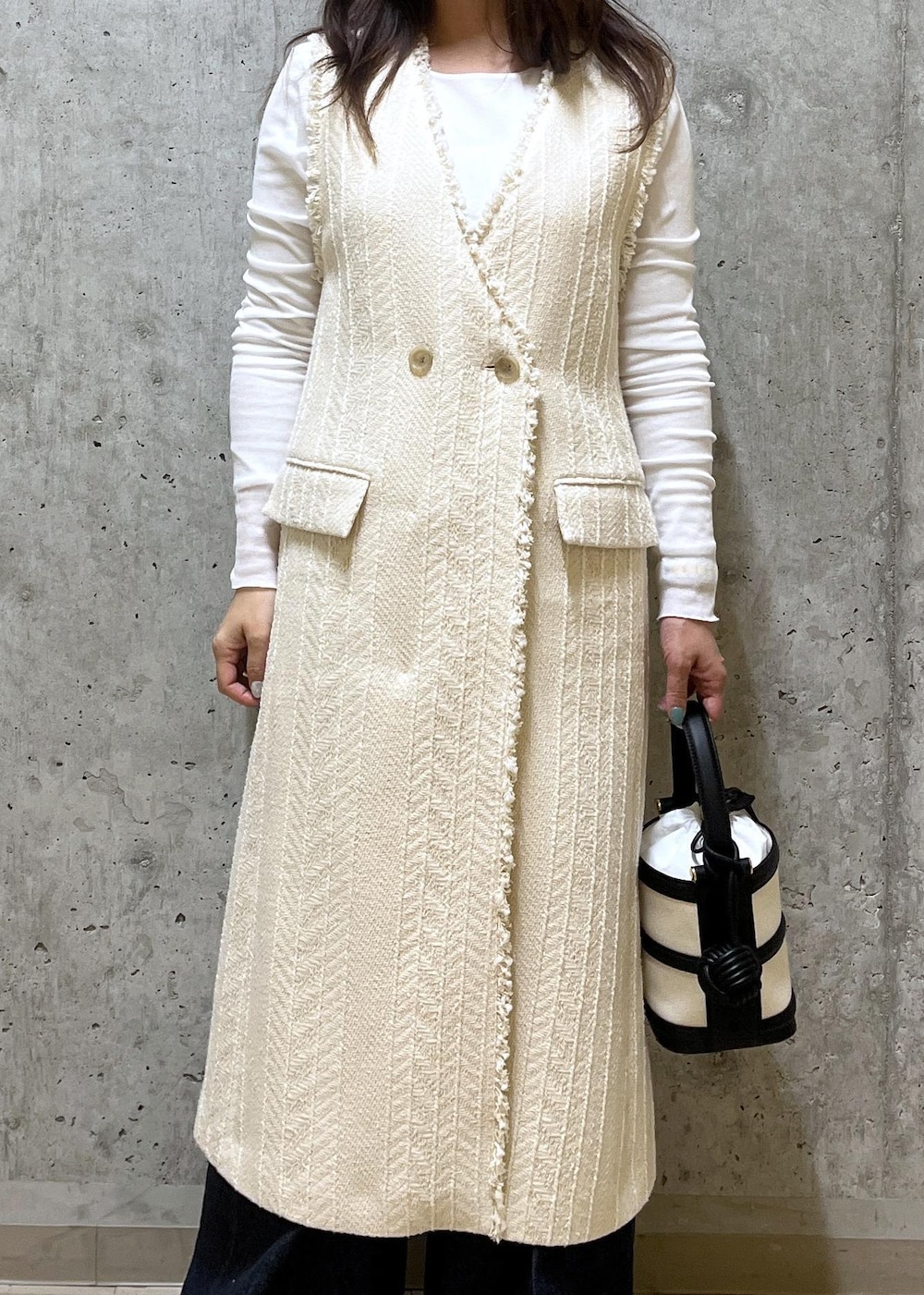 ブラック系のハンドバッグ、ホワイト系のパンプス、ホワイト系のTシャツ/カットソーを着用したレディースの春コーディネートの4枚目の写真