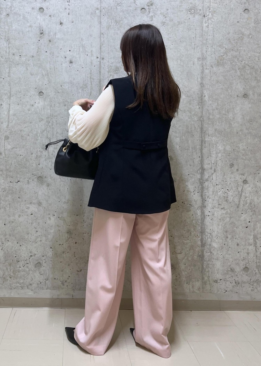 ブラック系のパンプス、ブラック系のハンドバッグ、ホワイト系のシャツ/ブラウスを着用したレディースの冬コーディネートの3枚目の写真