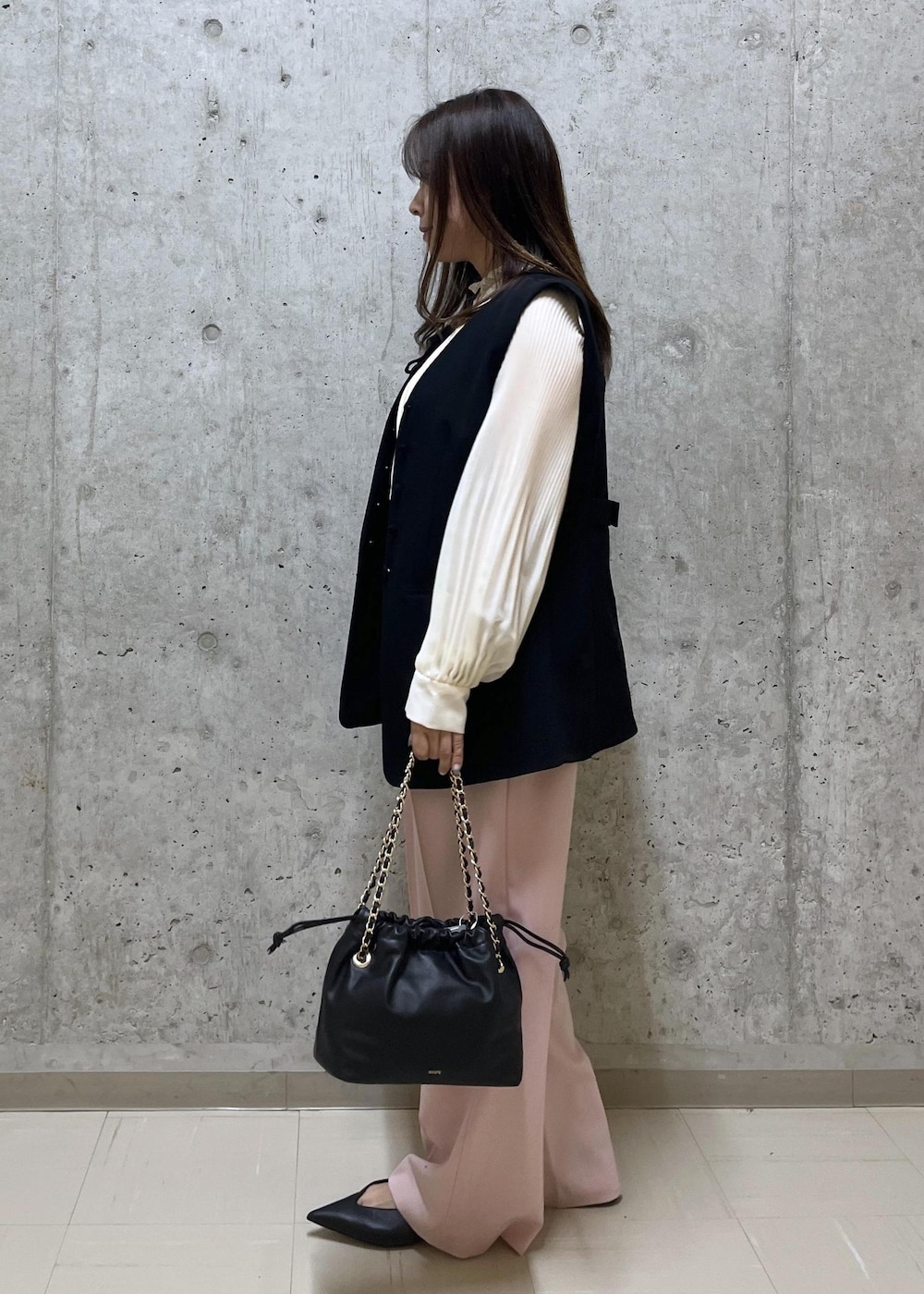 ブラック系のパンプス、ブラック系のハンドバッグ、ホワイト系のシャツ/ブラウスを着用したレディースの冬コーディネートの2枚目の写真