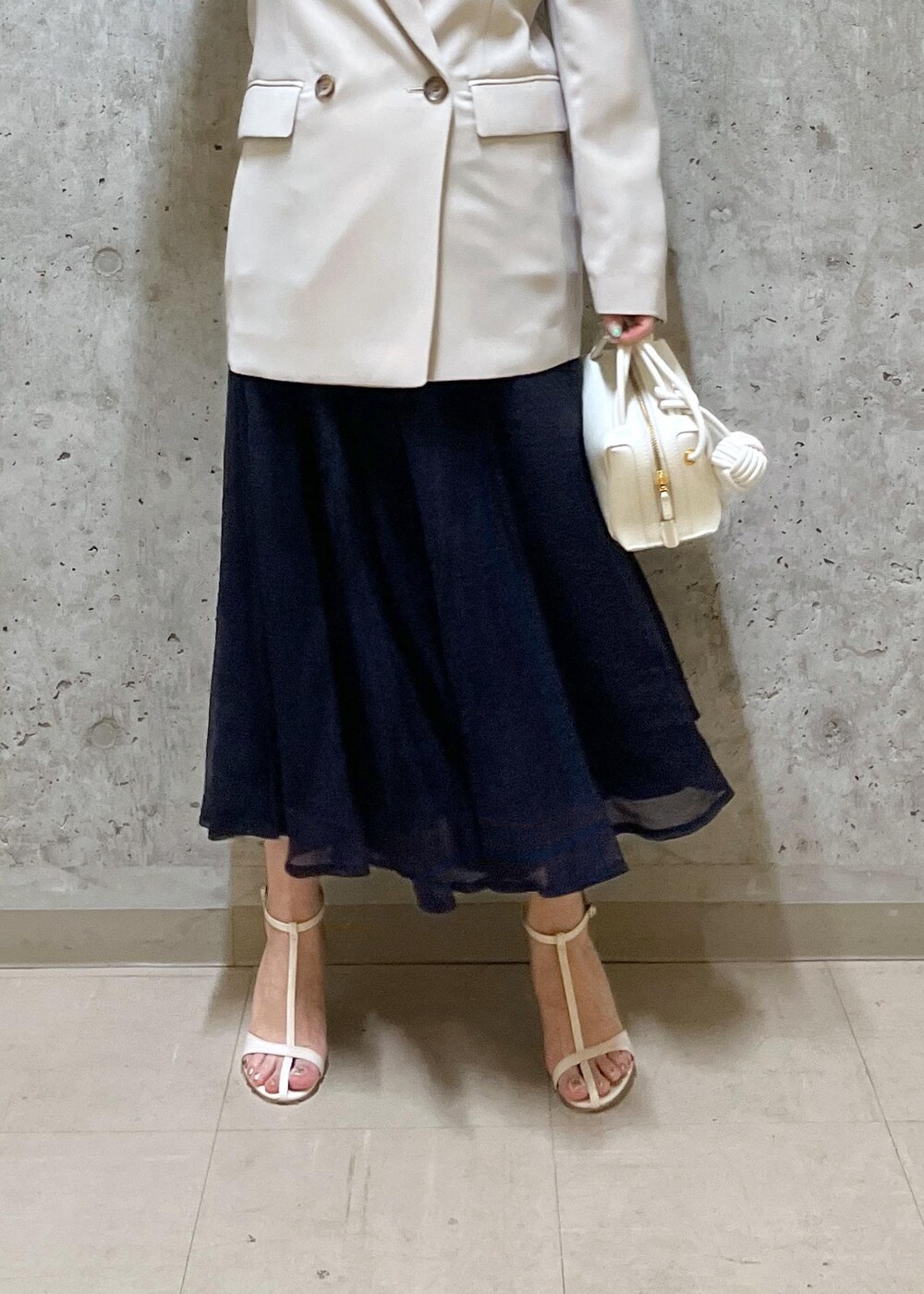 ブルー系のスカート、ホワイト系のサンダル、ホワイト系のショルダーバッグを着用したレディースの夏コーディネートの6枚目の写真