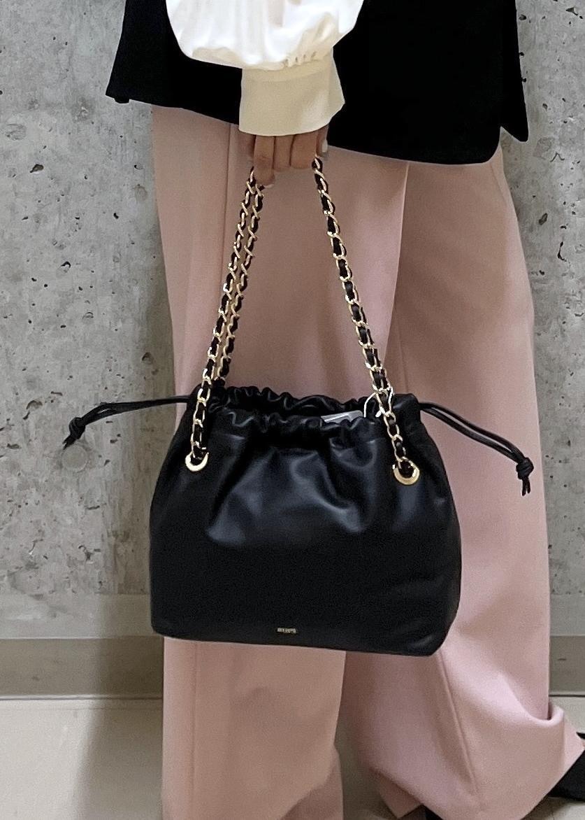 ブラック系のパンプス、ブラック系のハンドバッグ、ホワイト系のシャツ/ブラウスを着用したレディースの冬コーディネートの6枚目の写真