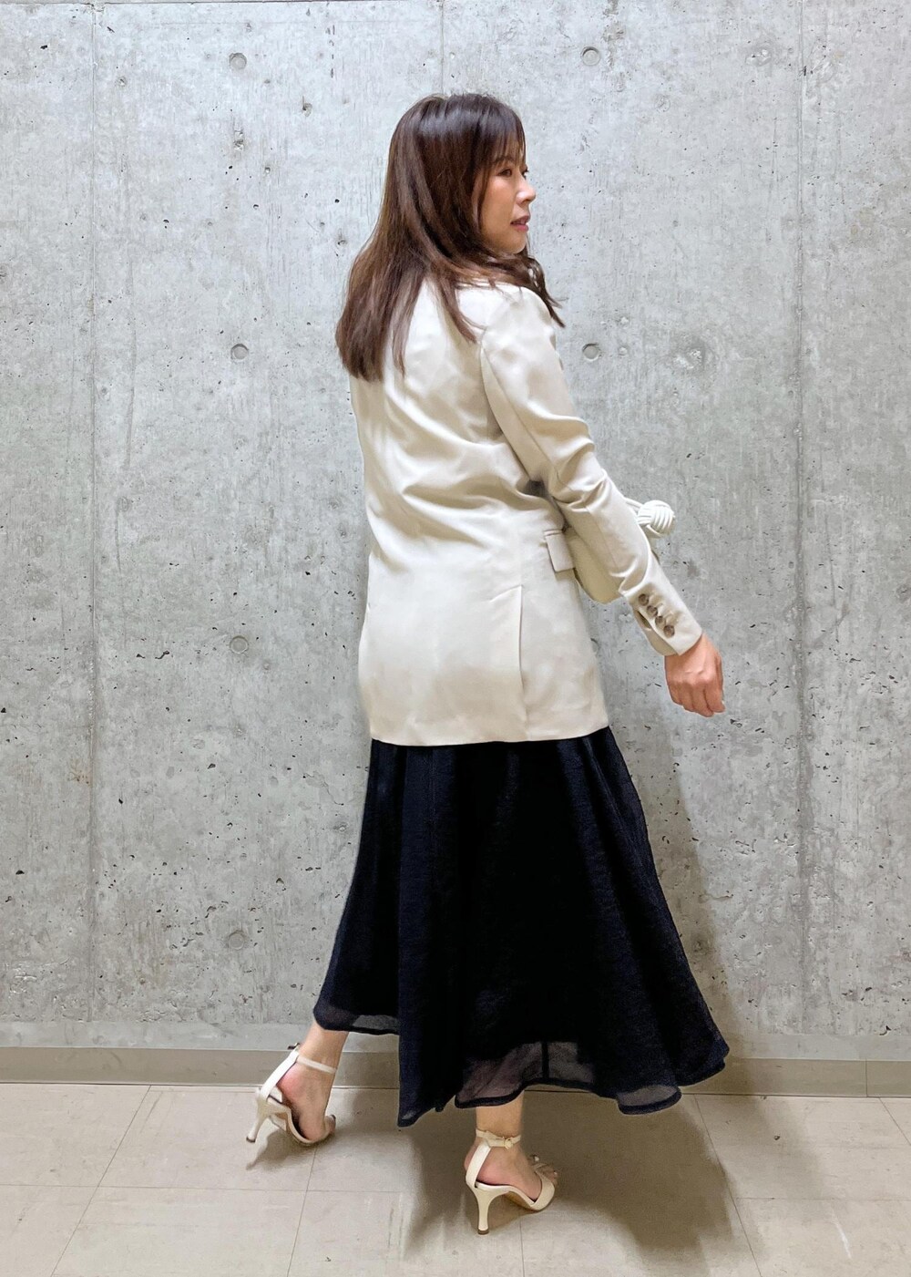 ブルー系のスカート、ホワイト系のサンダル、ホワイト系のショルダーバッグを着用したレディースの夏コーディネートの4枚目の写真