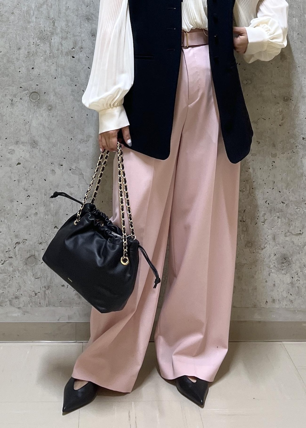 ブラック系のパンプス、ブラック系のハンドバッグ、ホワイト系のシャツ/ブラウスを着用したレディースの冬コーディネートの5枚目の写真