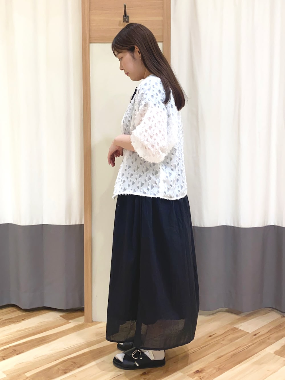 ホワイト系のシャツ/ブラウス、ブラック系のワンピース、ブルー系のハンドバッグを着用したレディースの春コーディネートの2枚目の写真