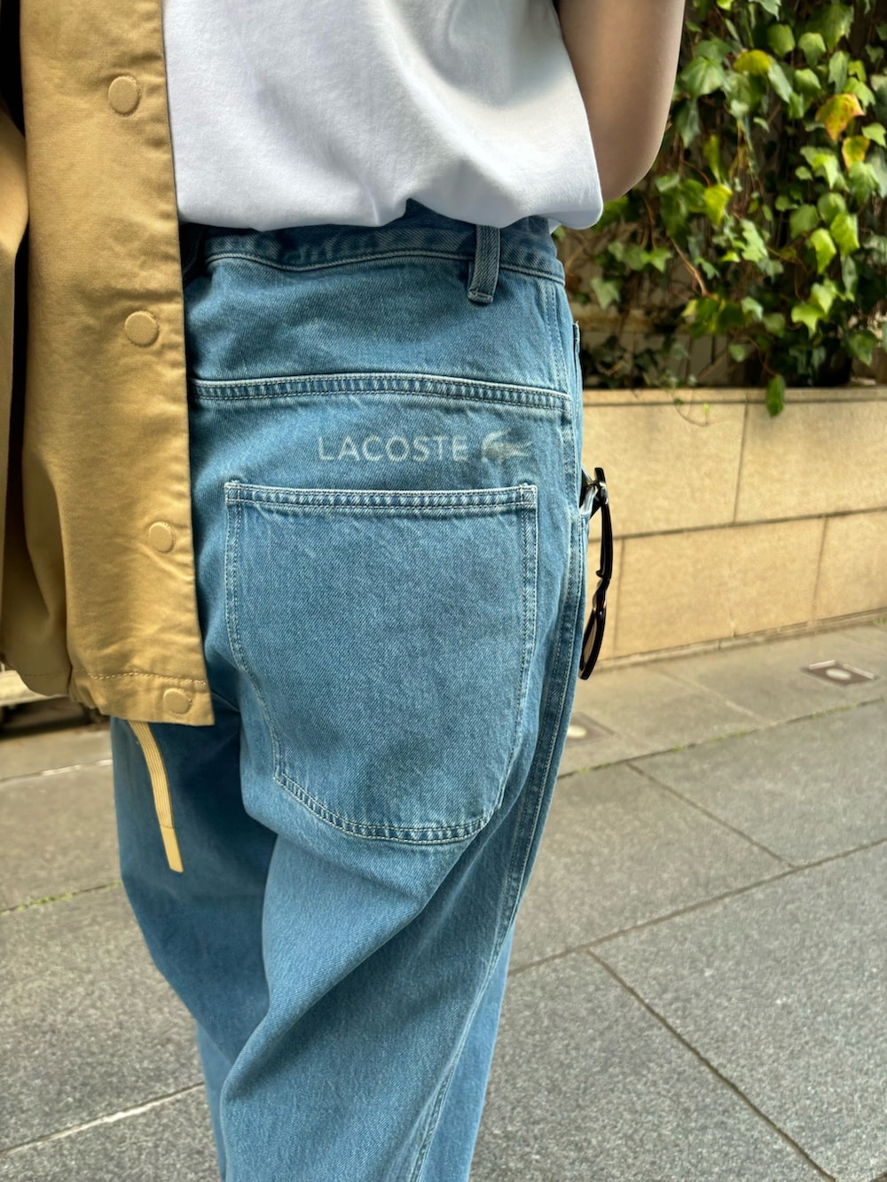 ブルー系のデニムパンツ、グリーン系のTシャツ/カットソー、ブラック系のスニーカーを着用したレディースの春コーディネートの8枚目の写真