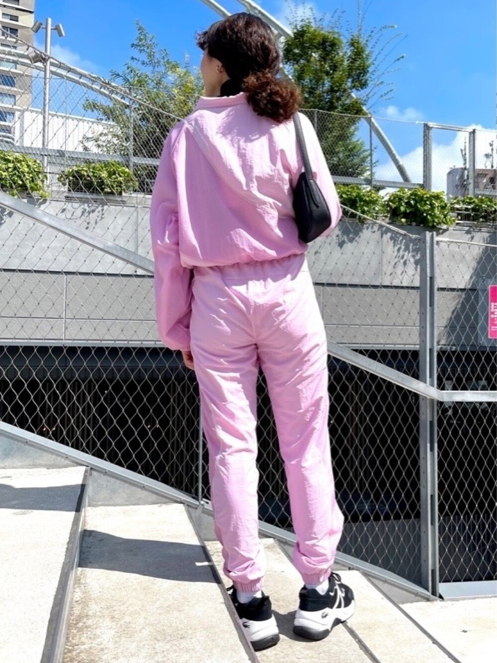 ピンク系のブルゾン、ピンク系のその他パンツ、ブラック系のニット/セーターを着用したレディースの春コーディネートの3枚目の写真