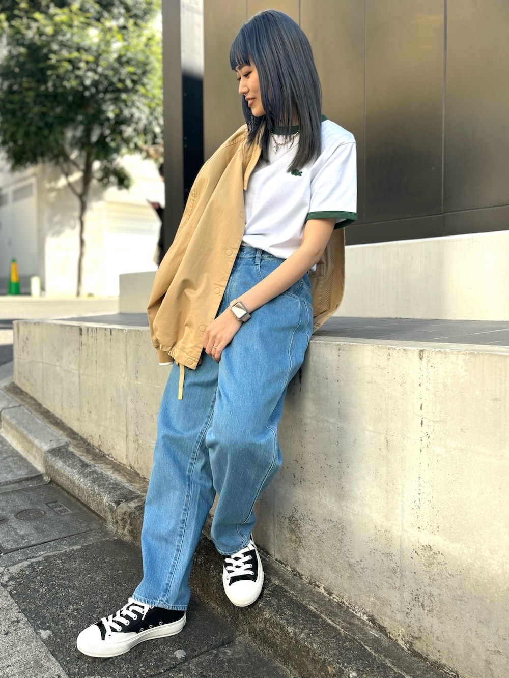 ブルー系のデニムパンツ、グリーン系のTシャツ/カットソー、ブラック系のスニーカーを着用したレディースの春コーディネートの5枚目の写真