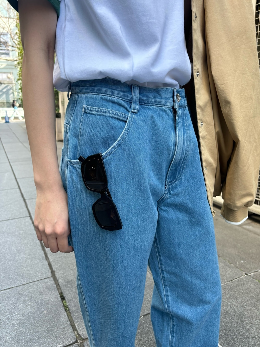 ブルー系のデニムパンツ、グリーン系のTシャツ/カットソー、ブラック系のスニーカーを着用したレディースの春コーディネートの7枚目の写真