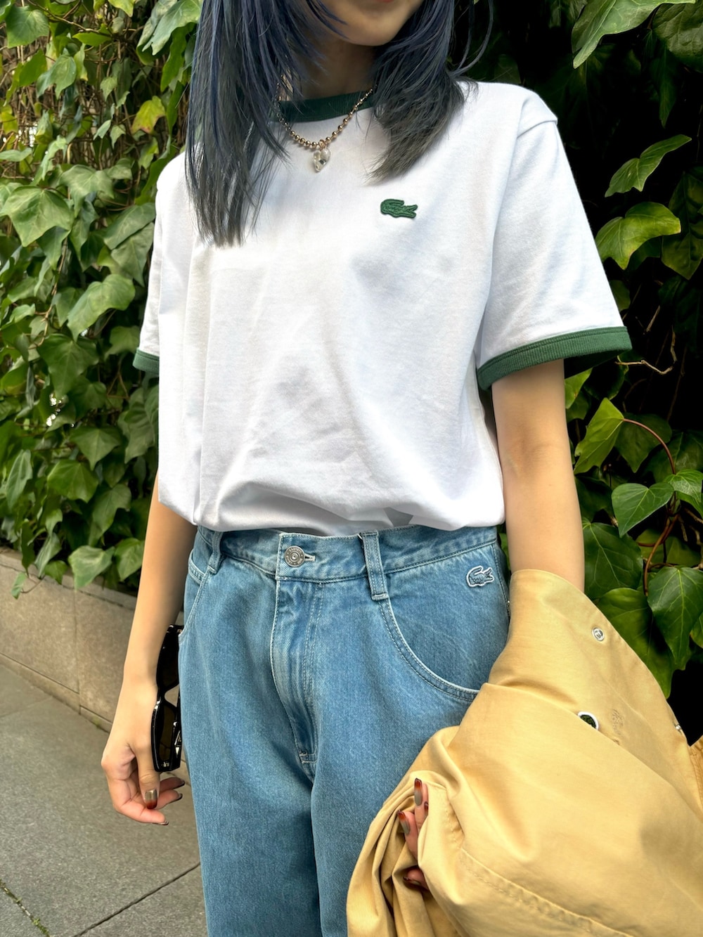 ブルー系のデニムパンツ、グリーン系のTシャツ/カットソー、ブラック系のスニーカーを着用したレディースの春コーディネートの6枚目の写真