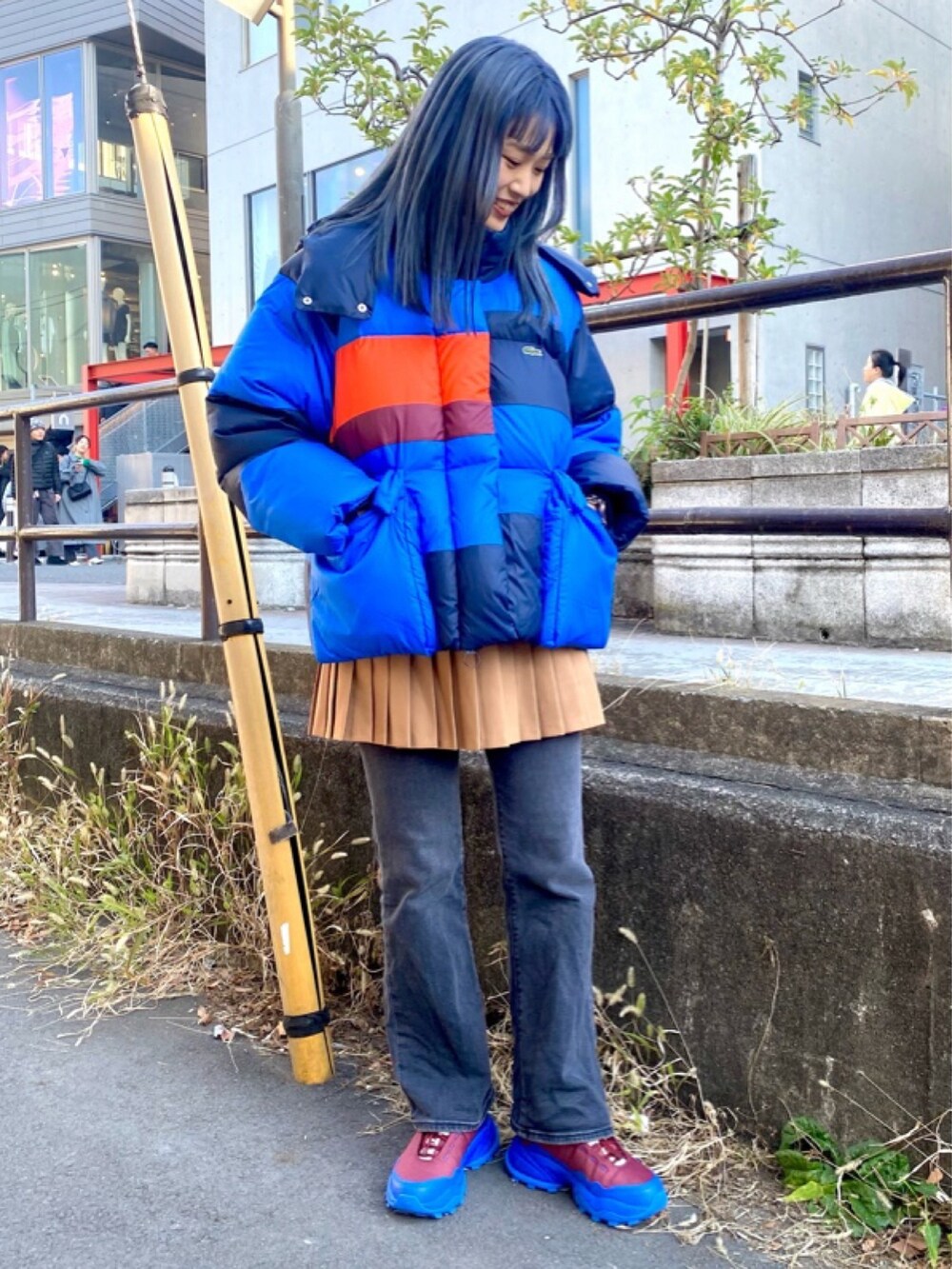 ブラウン系のスカート、レッド系のスニーカーを着用したレディースの春コーディネートの3枚目の写真