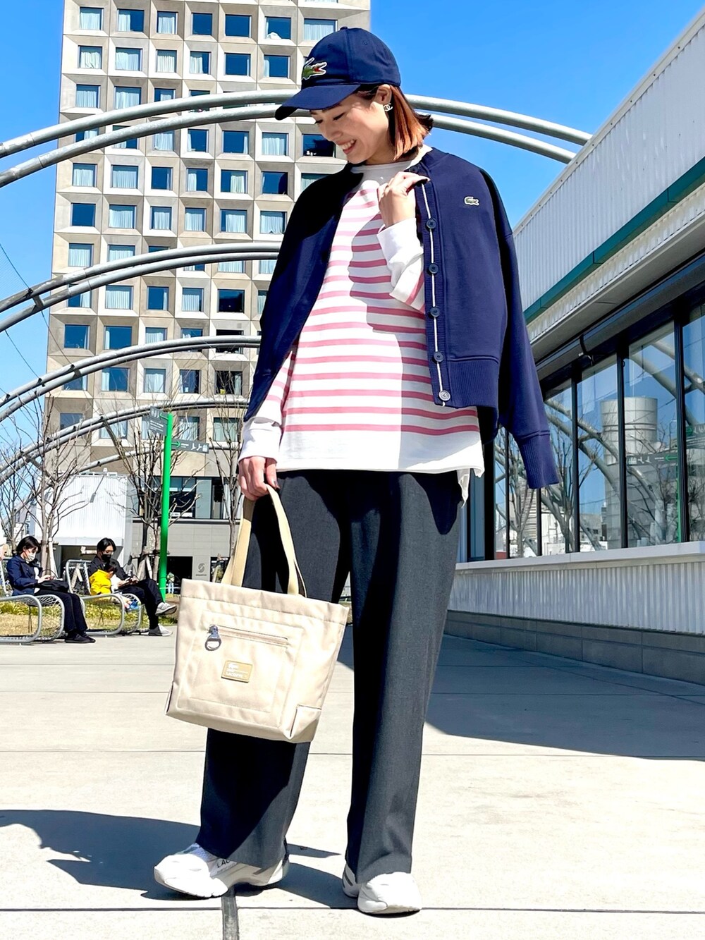 ブルー系のトップス、グレー系のその他パンツ、ホワイト系のスニーカーを着用したレディースの春コーディネートの2枚目の写真