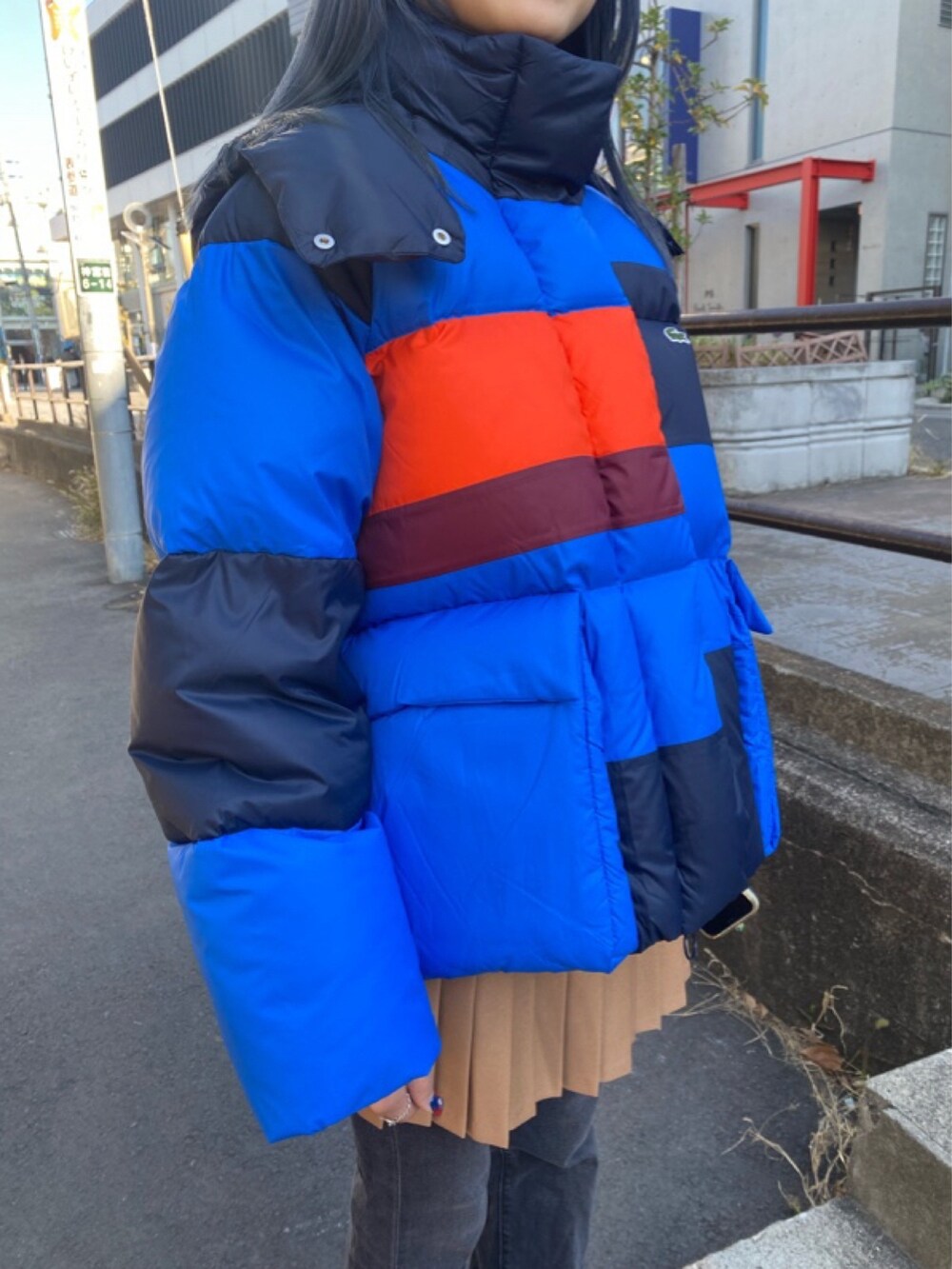 ブラウン系のスカート、レッド系のスニーカーを着用したレディースの春コーディネートの5枚目の写真