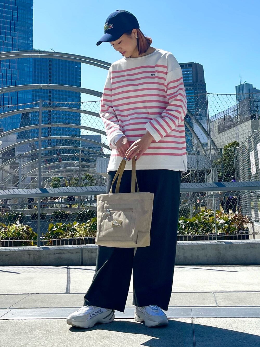ブルー系のトップス、グレー系のその他パンツ、ホワイト系のスニーカーを着用したレディースの春コーディネートの4枚目の写真