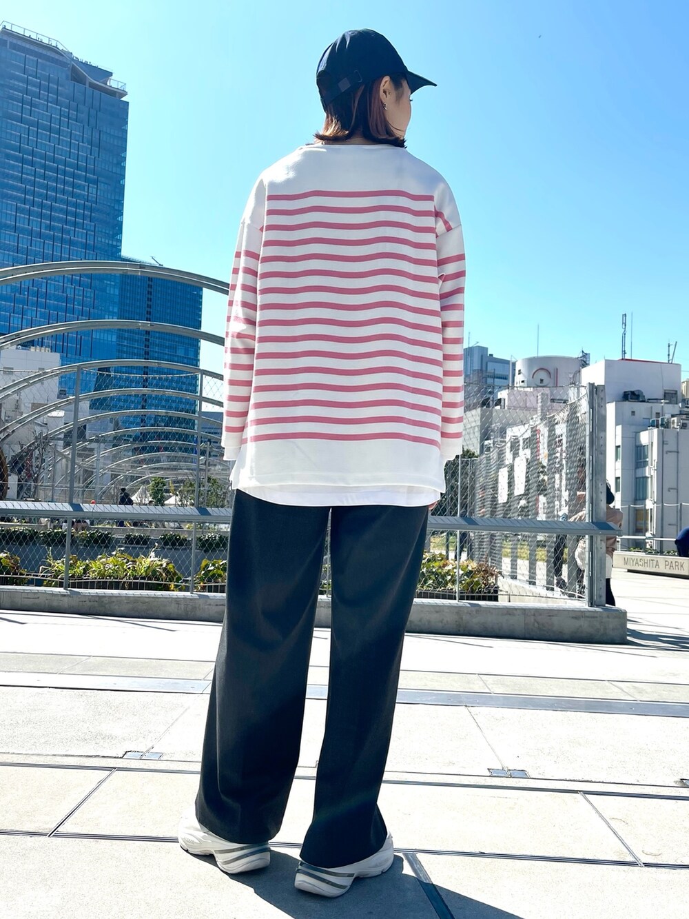 ブルー系のトップス、グレー系のその他パンツ、ホワイト系のスニーカーを着用したレディースの春コーディネートの6枚目の写真