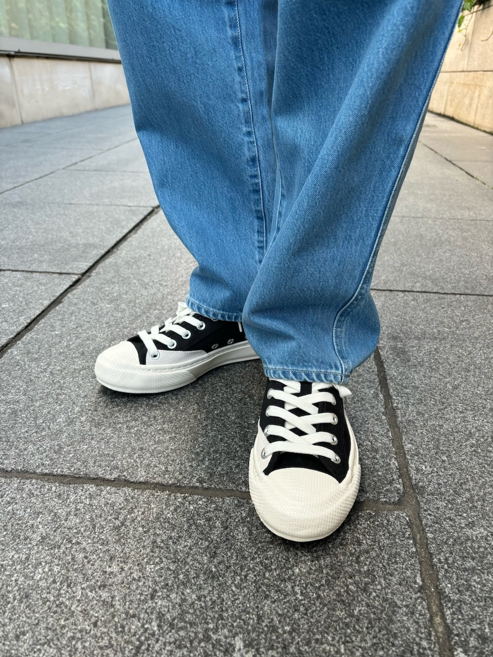 ブルー系のデニムパンツ、グリーン系のTシャツ/カットソー、ブラック系のスニーカーを着用したレディースの春コーディネートの9枚目の写真