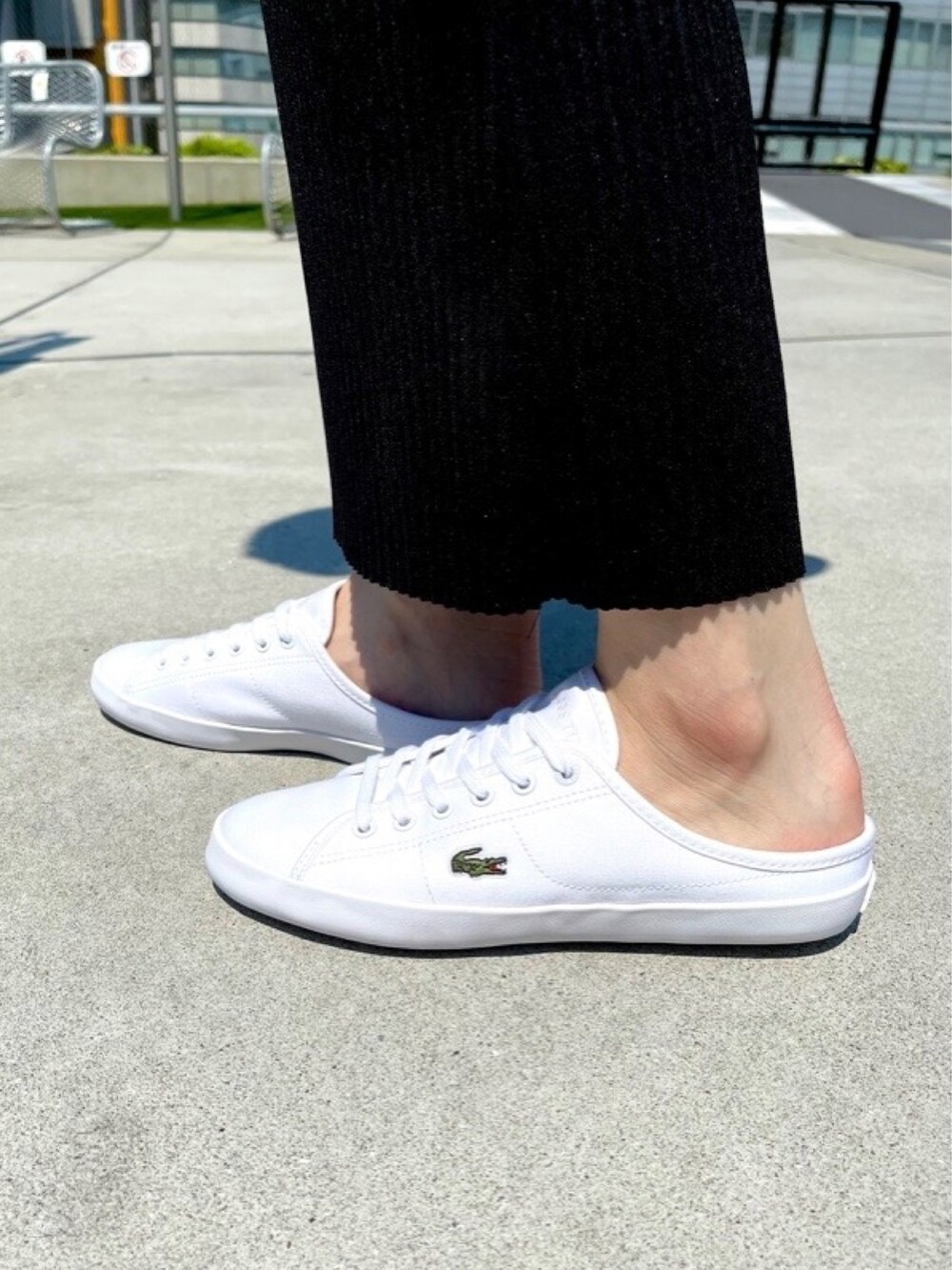 イエロー系のトートバッグ、ブルー系のポロシャツ、ホワイト系のスニーカーを着用したレディースの春コーディネートの5枚目の写真