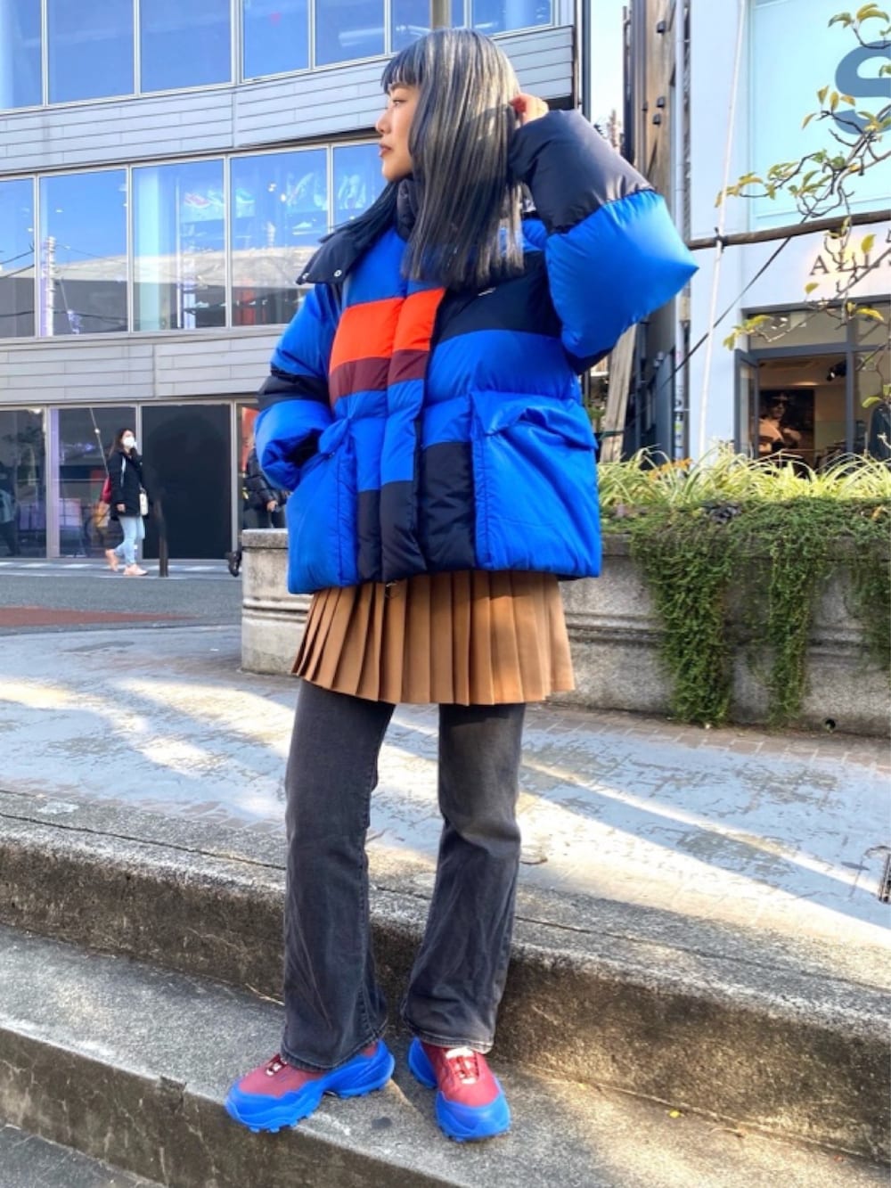 ブラウン系のスカート、レッド系のスニーカーを着用したレディースの春コーディネートの2枚目の写真