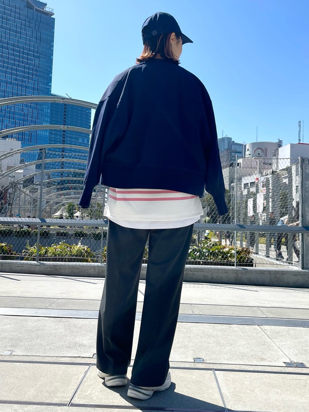 ブルー系のトップス、グレー系のその他パンツ、ホワイト系のスニーカーを着用したレディースの春コーディネートの5枚目の写真