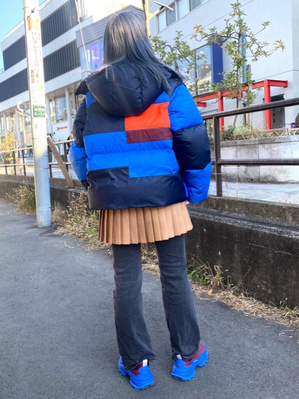 ブラウン系のスカート、レッド系のスニーカーを着用したレディースの春コーディネートの4枚目の写真