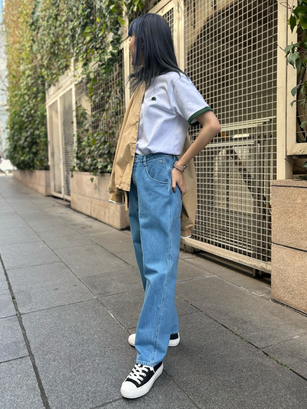 ブルー系のデニムパンツ、グリーン系のTシャツ/カットソー、ブラック系のスニーカーを着用したレディースの春コーディネートの3枚目の写真