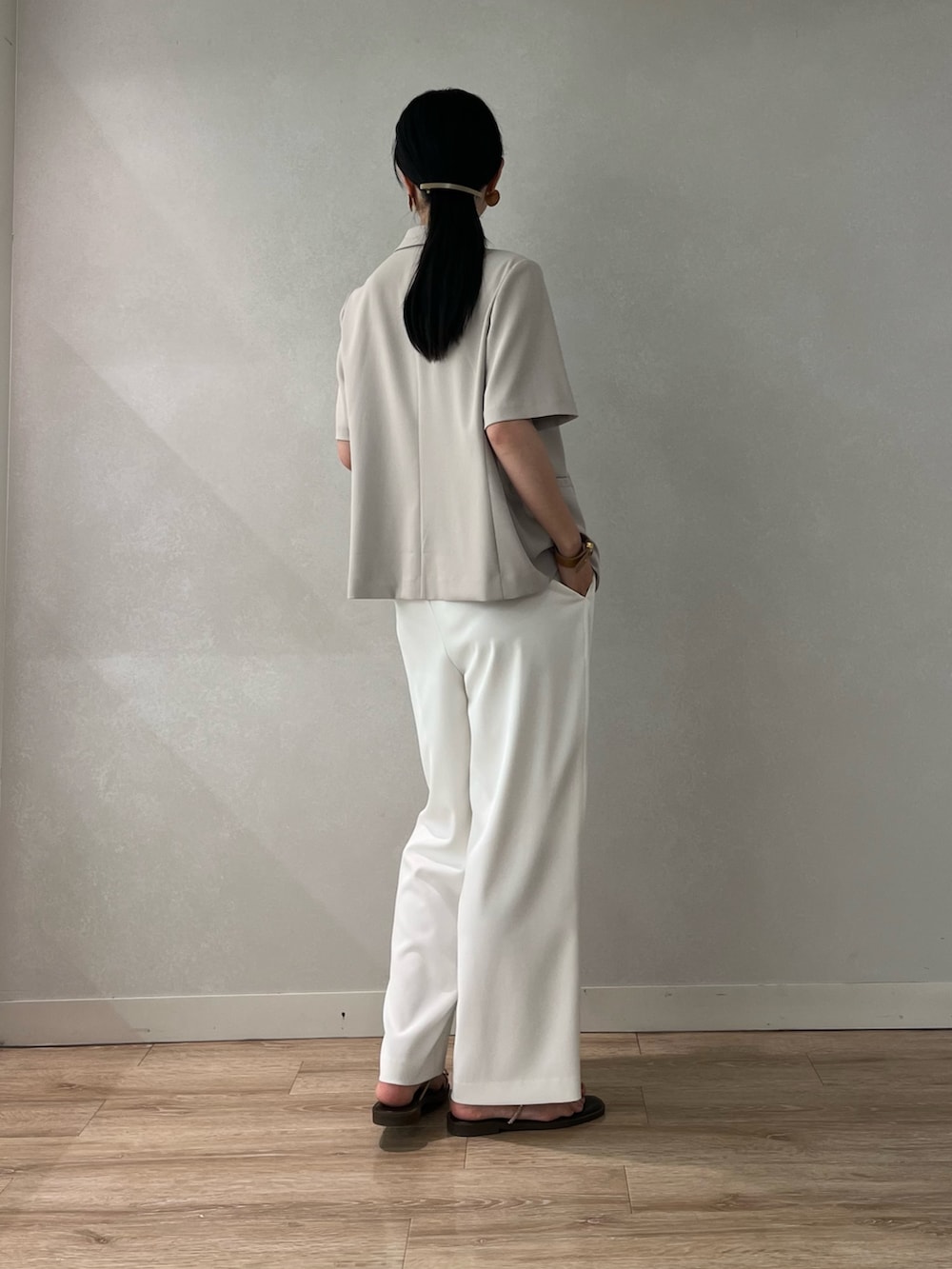 ベージュ系のテーラードジャケット、ホワイト系のその他パンツ、ブラウン系のサンダルを着用したレディースの夏コーディネートの4枚目の写真