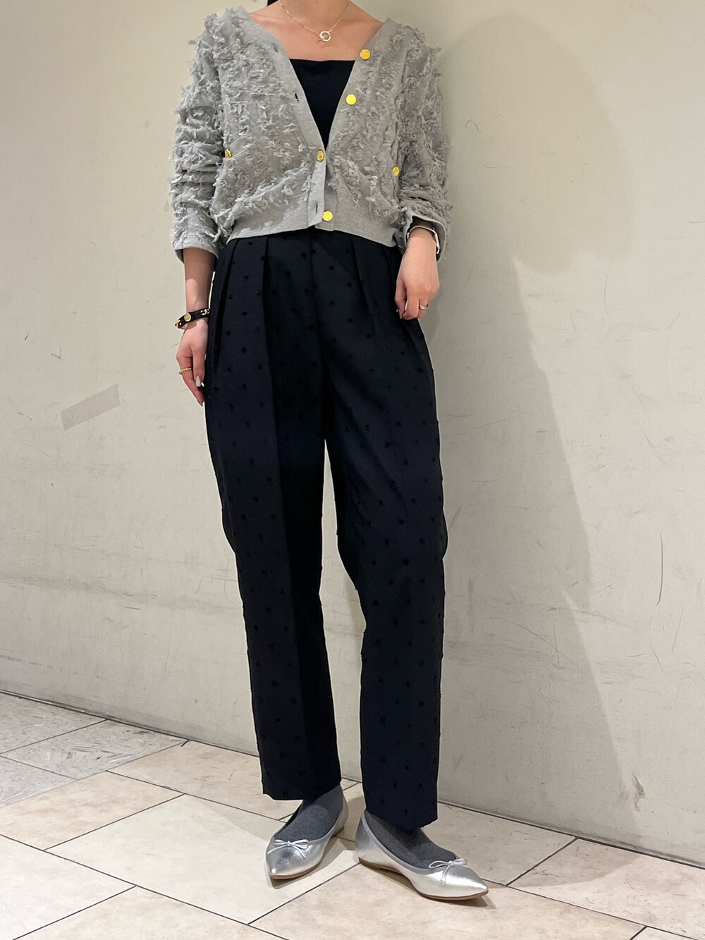 ブラック系のその他パンツ、グレー系のカーディガン/ボレロ、シルバー系のネックレスを着用したレディースの春コーディネートの2枚目の写真